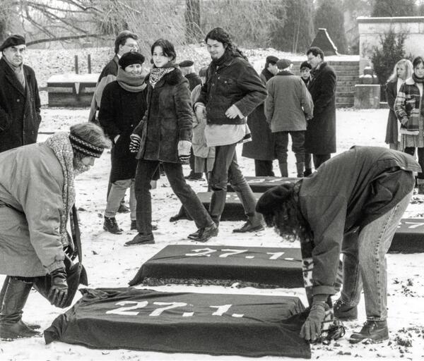 Bild vergrößern: Am 27. Januar 1996 wird zum ersten Mal der Auschwitz-Gedenktag bundesweit veranstaltet. Mitglieder der Initiative fr Mahn- und Gedenksttten verhllen im Luitpoldpark die Liegesteine mit schwarzen Tchern mit der Aufschrift 27.1.