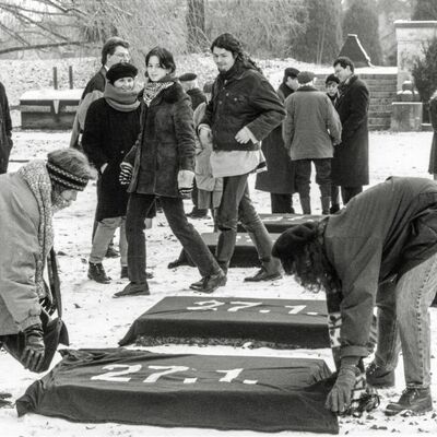 Bild vergr&ouml;&szlig;ern: Am 27. Januar 1996 wird zum ersten Mal der Auschwitz-Gedenktag bundesweit veranstaltet. Mitglieder der Initiative f&uuml;r Mahn- und Gedenkst&auml;tten verh&uuml;llen im Luitpoldpark die Liegesteine mit schwarzen T&uuml;chern mit der Aufschrift &raquo;27.1.&laquo;